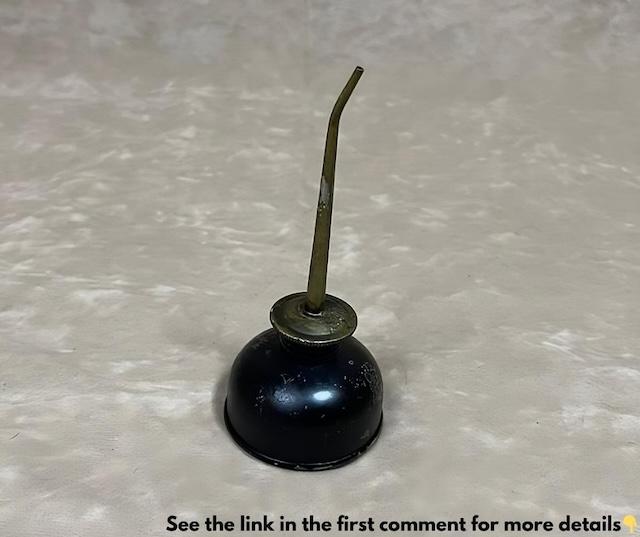 A classic vintage midget oil can dispenser, often used for maintaining machinery in times past. Its small, iconic design brings back memories of a different era